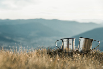 metal cups on a background of mountains
