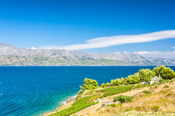 View on a landscape with a rural residence on The Brac island at the Adriatic sea with a mountain coast background of Croatia, Europe.