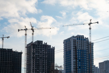 Fototapeta na wymiar Construction of residential multi-storey buildings with the help of four tower cranes
