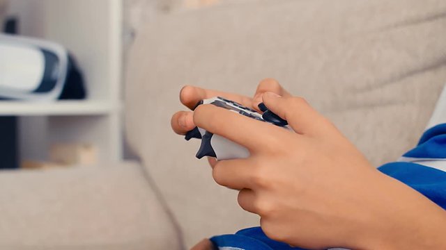 Hands of a boy playing video game console, hold the joystick, 4k