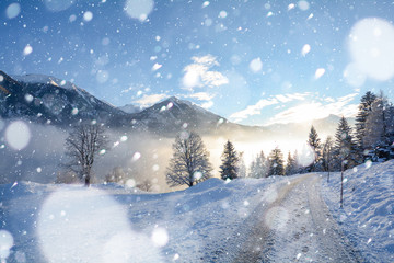 Fototapeta na wymiar Vereiste Strasse bei Schneefall in den österreichischen Alpen im Winter, Schneeketten Pflicht in Österreich