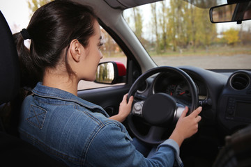 Young woman driving car on city road