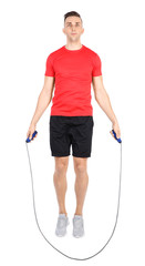 Full length portrait of young sportive man training with jump rope on white background