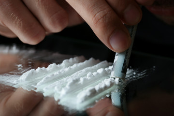 Drug addict taking cocaine at table, closeup view