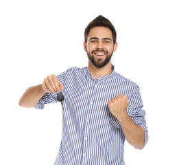 Happy young man with car key on white background. Getting driving license