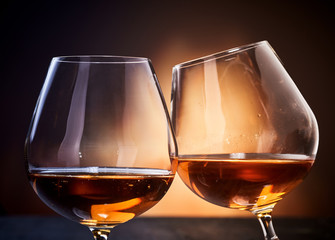 Two cognac glasses clinking