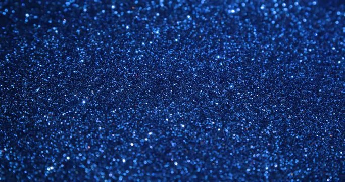 Blue glitter texture surface rotating. Close up 4k backdrop footage.