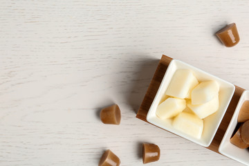 Flat lay composition with milk and coffee ice cubes on white wooden background. Space for text