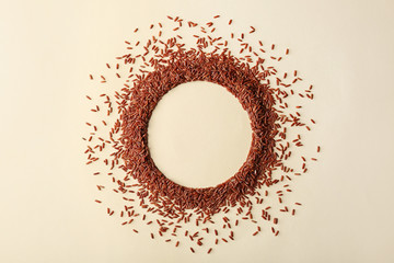 Round frame made with brown rice on color background, top view. Space for text