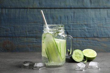 Mason jar with fresh cucumber water on table