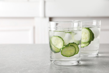 Glasses of fresh cucumber water on table. Space for text