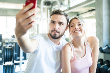 Fototapeta na wymiar Caucasian sport couple take selfies photo after work out in gym