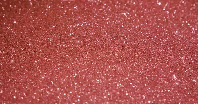 Rose gold glitter texture surface rotating. Close up 4k backdrop footage.