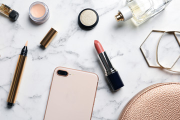 Flat lay composition with lipstick and smartphone on marble background