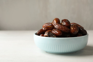 Bowl with sweet dates on table, space for text. Dried fruit as healthy snack