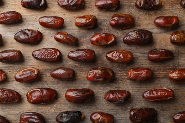 Flat lay composition with dates on wooden background. Dried fruit as healthy snack
