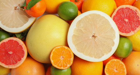 Fototapeta na wymiar Different citrus fruits as background, top view