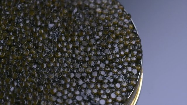 Caviar closeup. Black caviar rotated on black background. High quality natural sturgeon caviar close-up, rotation. Delicatessen. 4K UHD video footage 3840X2160