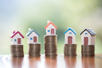 Mini house on stack of coins,Money and house, Real estate investment, Save money with stack coin,...