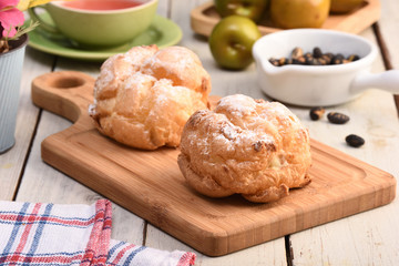Delicious cream puffs on a cutting board