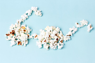popcorn laid out in the form of glasses on a blue background close-up, top view