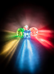 Multi color dice shinning in the dark by soft light