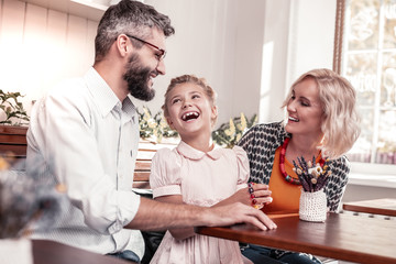 Nice delighted family sitting together at the table