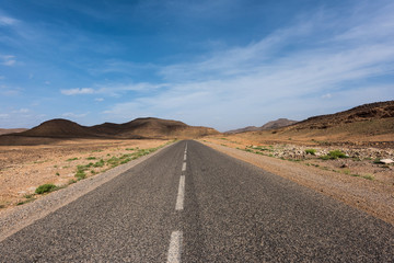 Moroccan highway featuring a rocky desert landscape on a road trip from Marrakesh to Merzouga