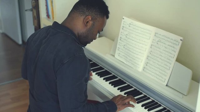 young man playing piano at home