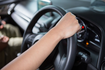 Fototapeta na wymiar Woman hand holding steering wheel