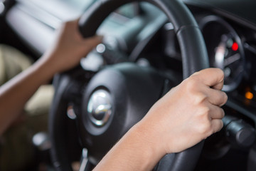 Woman hand holding steering wheel