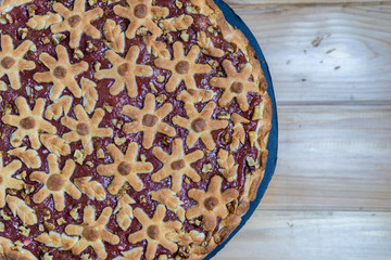cake with berries and rhubarb on a wooden table.
