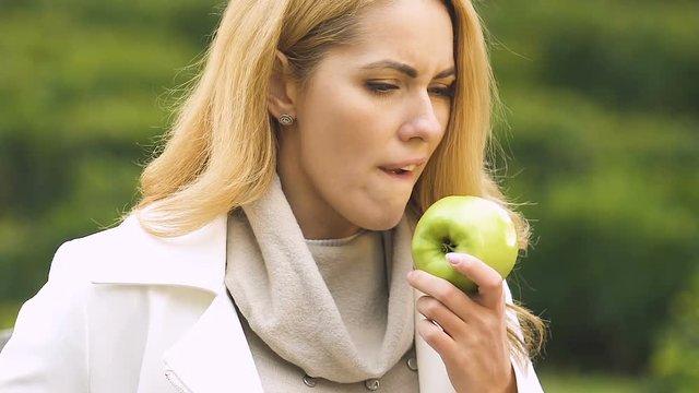 Pregnant female with big belly biting apple, suffering toxicosis, feeling sick