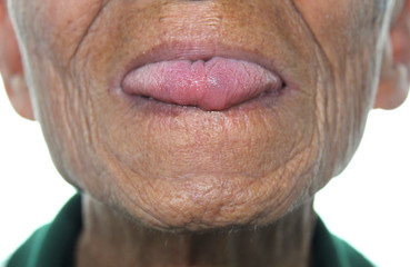 Close up face of Elderly Asian men show tongue out on white background.