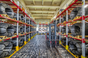 Factory stock wire. Wire spools lie on multi-tiered racks.