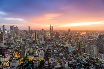 Aerial view of modern office and condominium building in Bangkok with orange sunset.