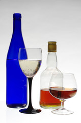 Glass of wine and bottles on light gray