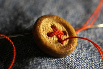 Old wooden button on jeans so close