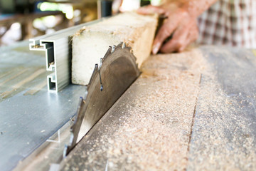 Man using Electric circular saw on table for cutting wood.