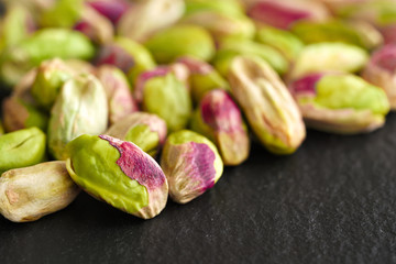 peeled pistachios on the black stone board