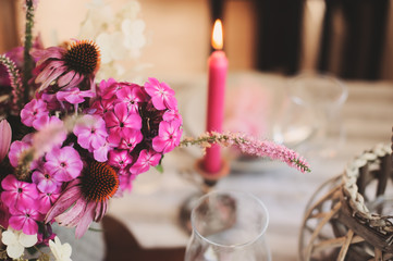 romantic summer dinner in cozy country house. Festive table setting with flowers and candles in purple tones