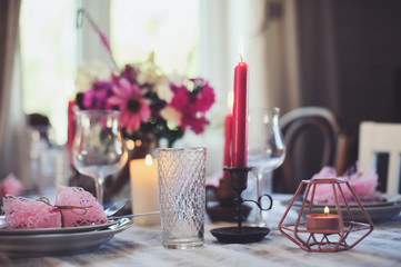 evening romantic table for two with candles and flowers in purple and white tones. Family dinner at home in summer country house.