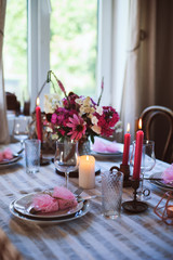 romantic summer dinner in cozy country house. Festive table setting with flowers and candles in purple tones