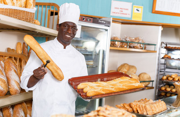 Worker of bakery preparing baked goods for sale