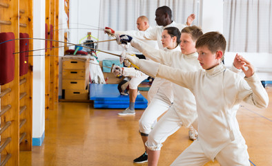 Positive group of athletes at fencing workout