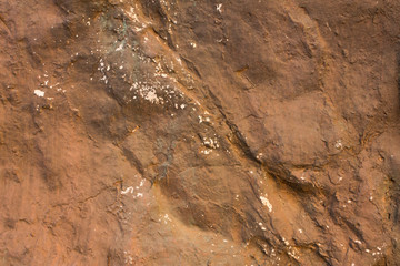 gray brown stone with deep relief, shadows and white spots. natural surface texture