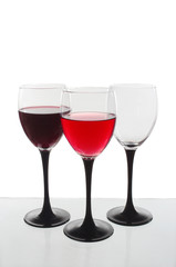 Two glasses of wine and one empty on a light background