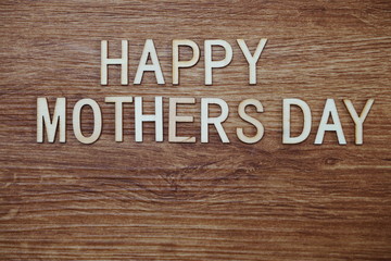 Happy Mothers Day text message on wooden background