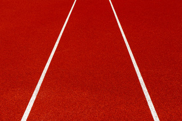 Red treadmill with white line at the stadium.