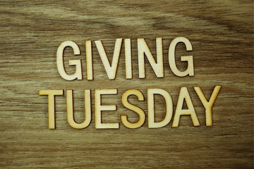 Giving Tuesday text message on wooden background